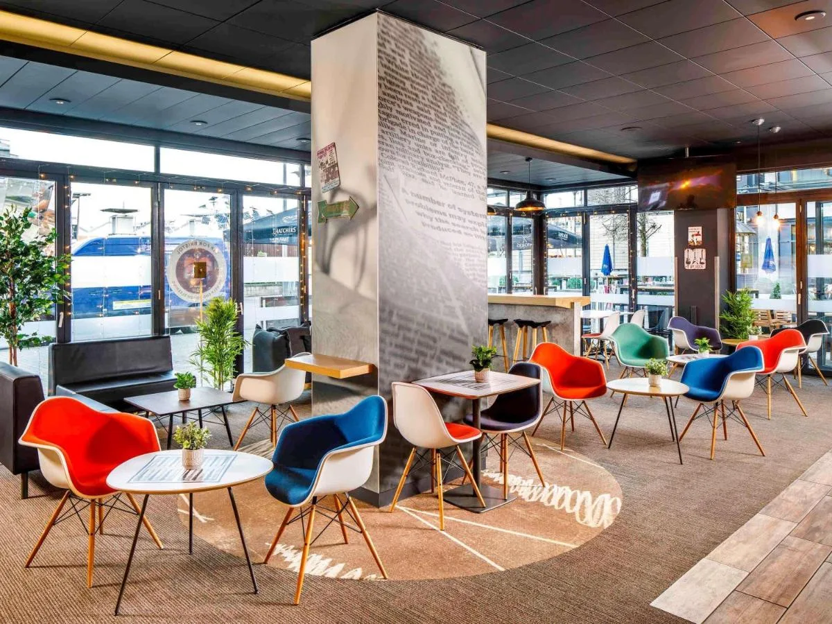 a group of tables and chairs in a room with windows at ibis Bristol Centre in Bristol